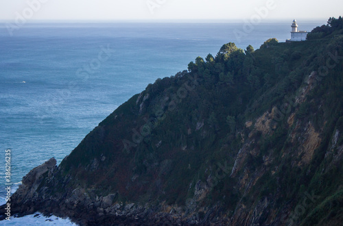 White lighthouse on the cliff, Bay of Biscay, Spain. Lighthouse on scenic seacoast. Aerial view of the sea from mountain. Panorama of Atlantic ocean harbor.  Marine navigation concept.  © Nataliia