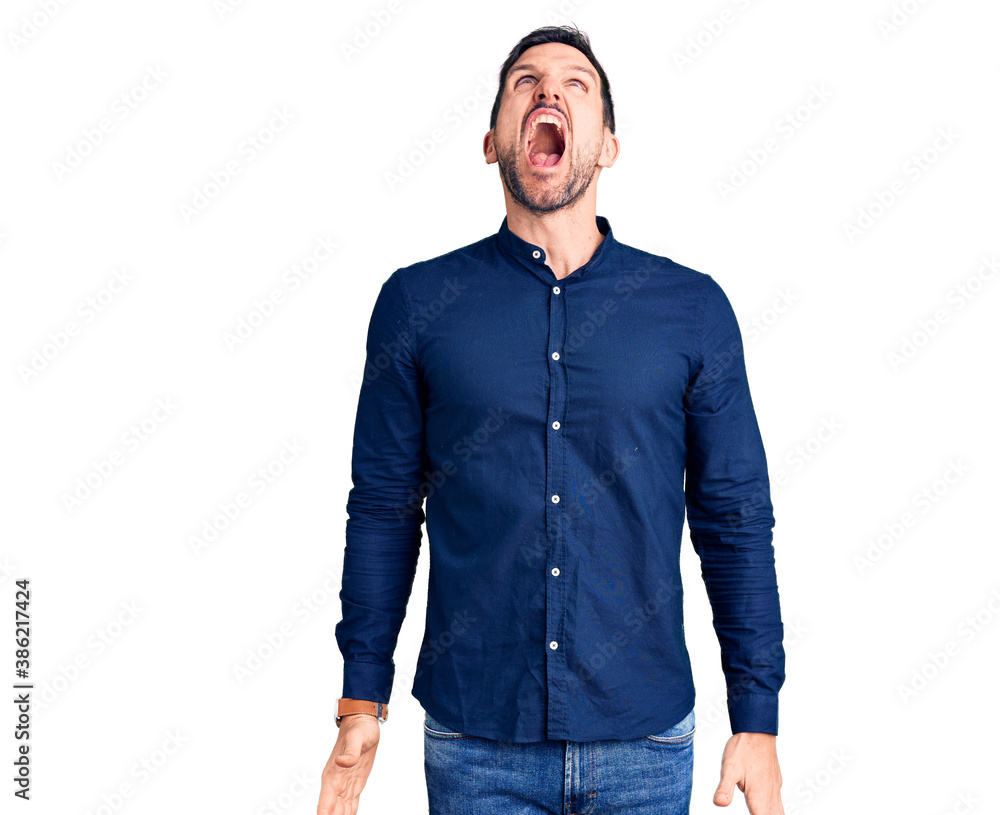 Young handsome man wearing casual shirt angry and mad screaming frustrated and furious, shouting with anger. rage and aggressive concept. Young handsome man wearing casual shirt angry and mad screaming frustrated and furious, shouting with anger. rage and aggressive concept.
