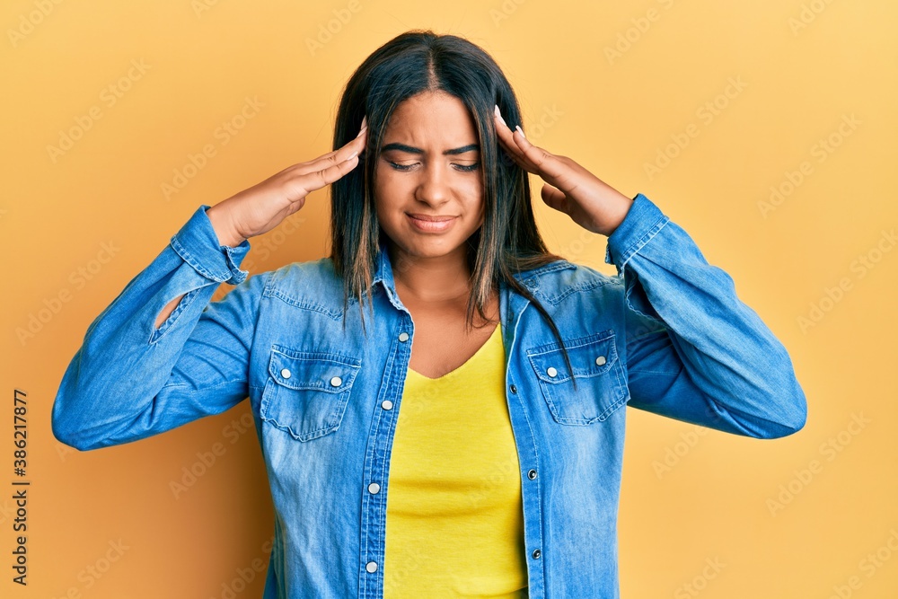 Young latin girl wearing casual clothes with hand on head, headache because stress. suffering migraine. Young latin girl wearing casual clothes with hand on head, headache because stress. suffering migraine.