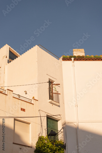 white buildings detail with sunlight and a blue sky at Cadaques coastal town, Girona, Spain vertical