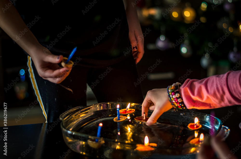 Naklejka premium christmas traditional customs - nut shell with burning candle floating on water