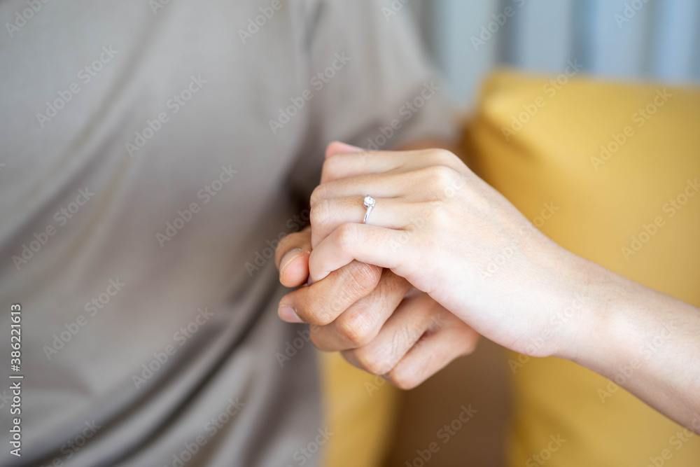 hands of Asian man giving ring engagement wedding to happy exciting woman sitting in couch in living room ar home. hands of Asian man giving ring engagement wedding to happy exciting woman sitting in couch in living room ar home.