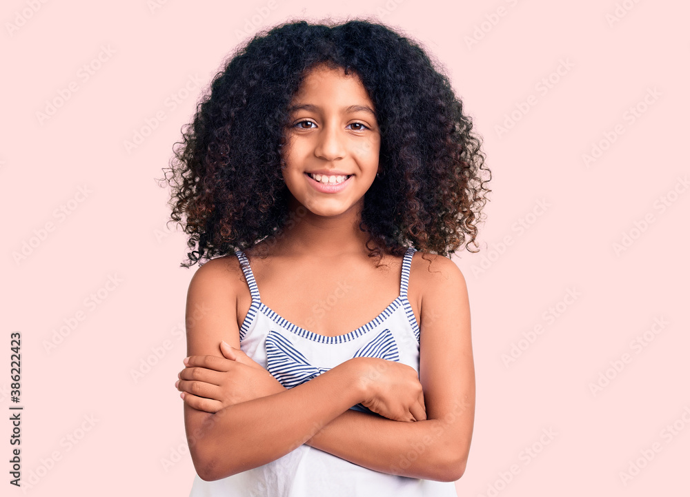 African american child with curly hair wearing casual clothes happy face smiling with crossed arms looking at the camera. positive person. African american child with curly hair wearing casual clothes happy face smiling with crossed arms looking at the camera. positive person.