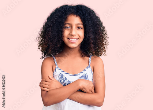 African american child with curly hair wearing casual clothes happy face smiling with crossed arms looking at the camera. positive person.