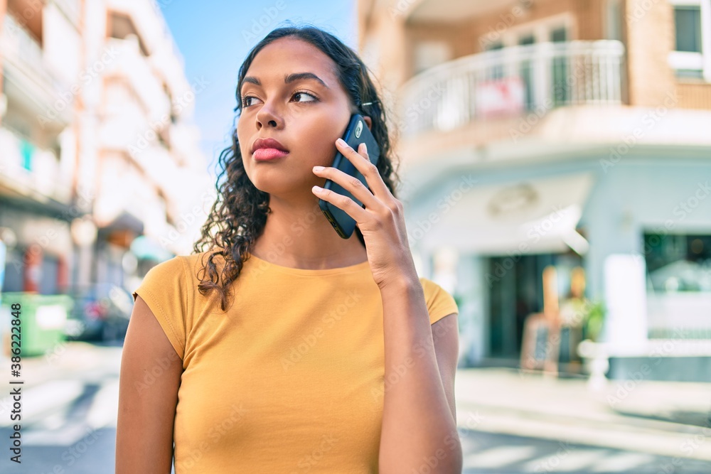 Young african american girl with unhappy expression talking on the smartphone at city.