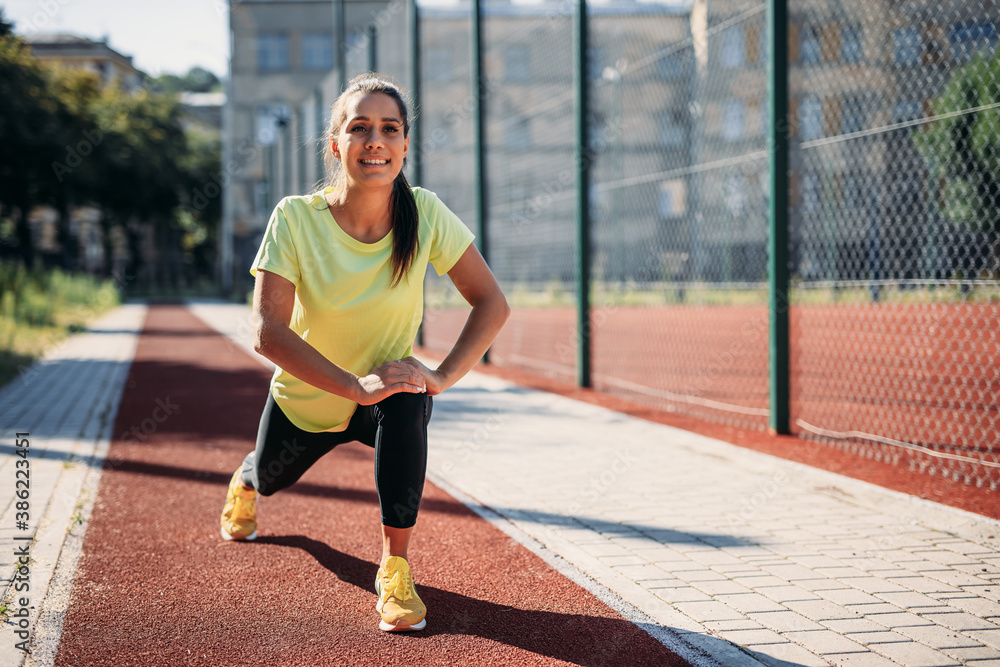 Obraz premium Happy active woman stretching legs during morning time