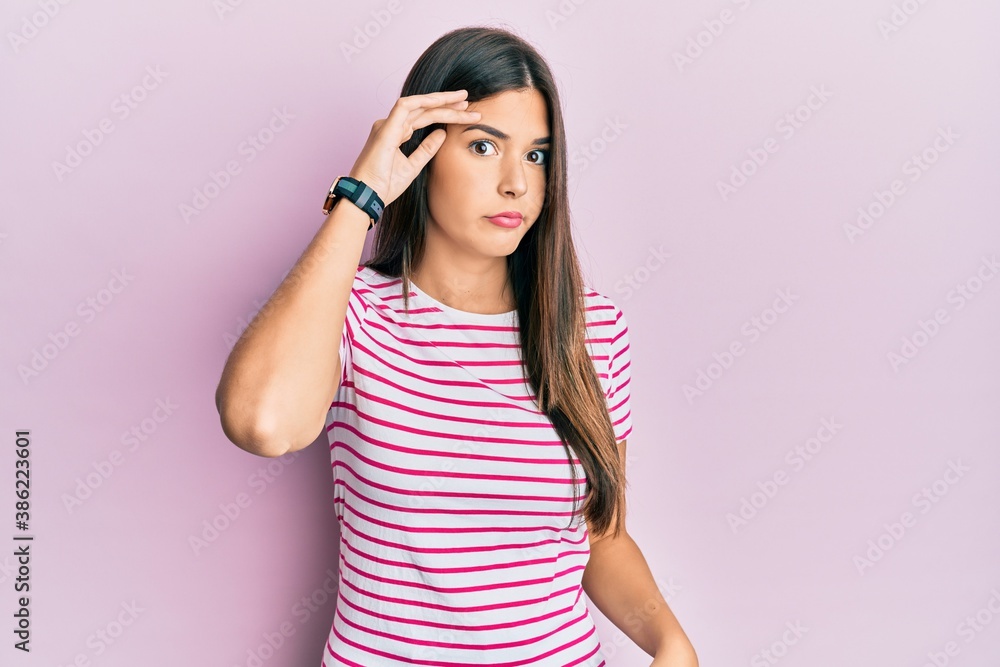 Young brunette woman wearing casual clothes over pink background worried and stressed about a problem with hand on forehead, nervous and anxious for crisis Young brunette woman wearing casual clothes over pink background worried and stressed about a problem with hand on forehead, nervous and anxious for crisis