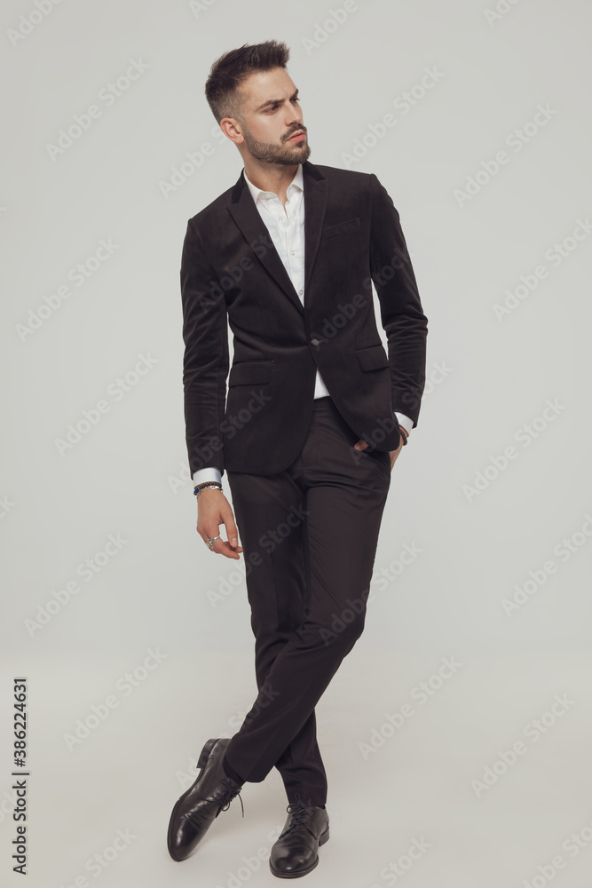 Confident fashion model looking away while standing with legs crossed Confident fashion model looking away while standing with legs crossed