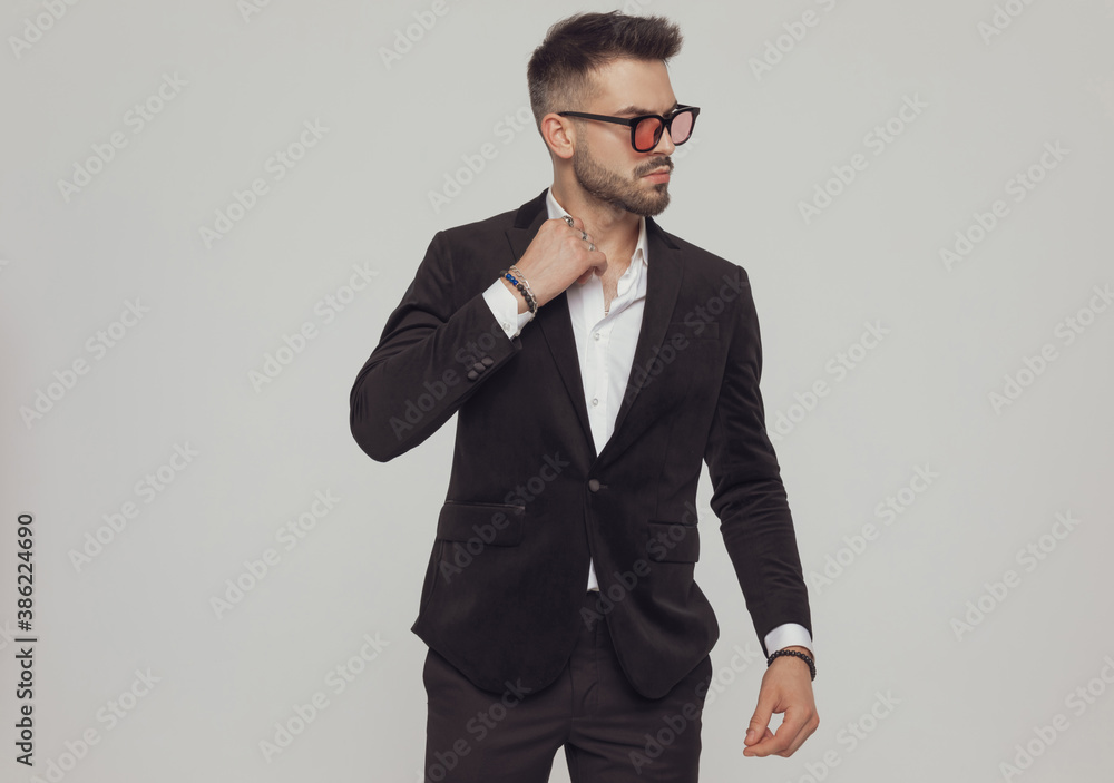 Confident fashion model arranging collar and looking away Confident fashion model arranging collar and looking away