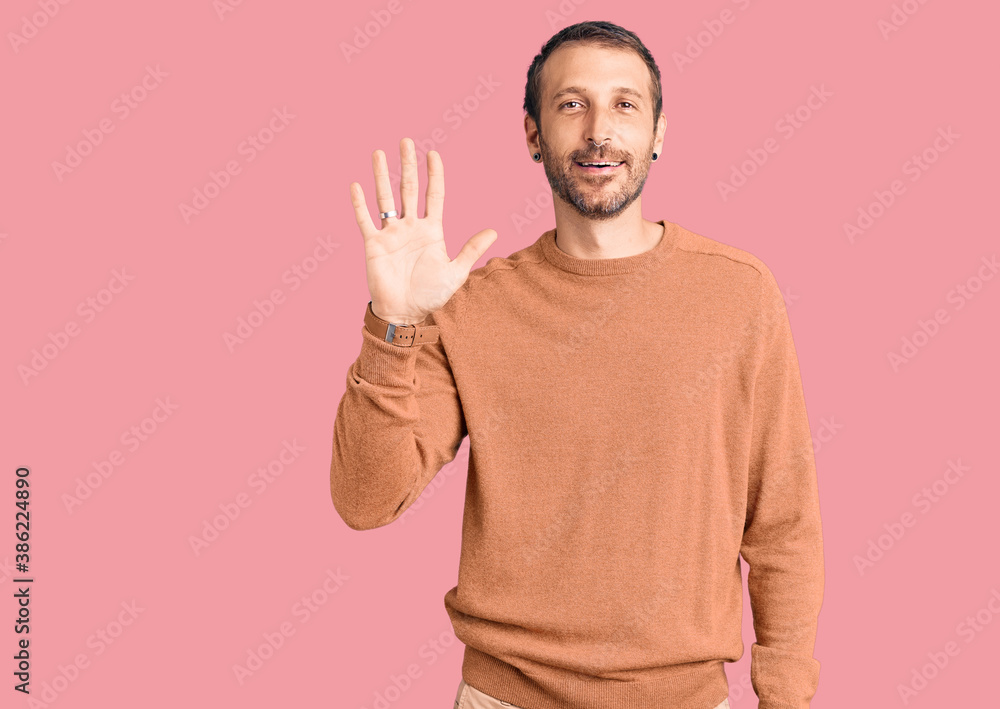 Young handsome man wearing casual clothes showing and pointing up with fingers number five while smiling confident and happy. Young handsome man wearing casual clothes showing and pointing up with fingers number five while smiling confident and happy.