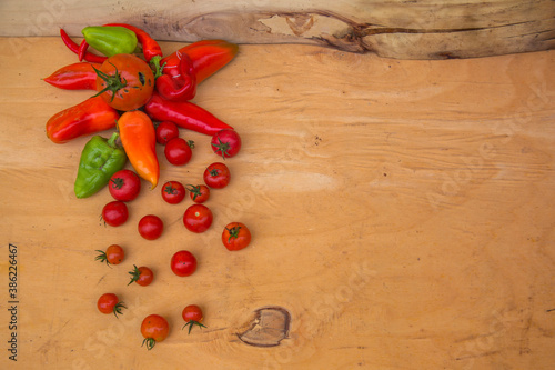 Red peppers  and cherry tomatoes over wooden background