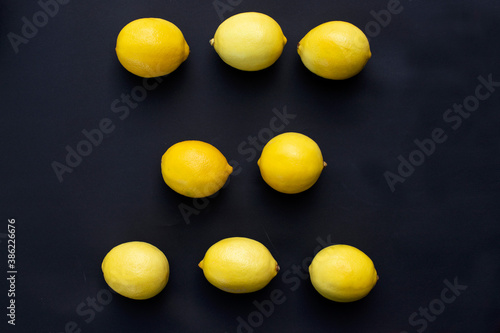 three rows of fresh lemons lie on a black background