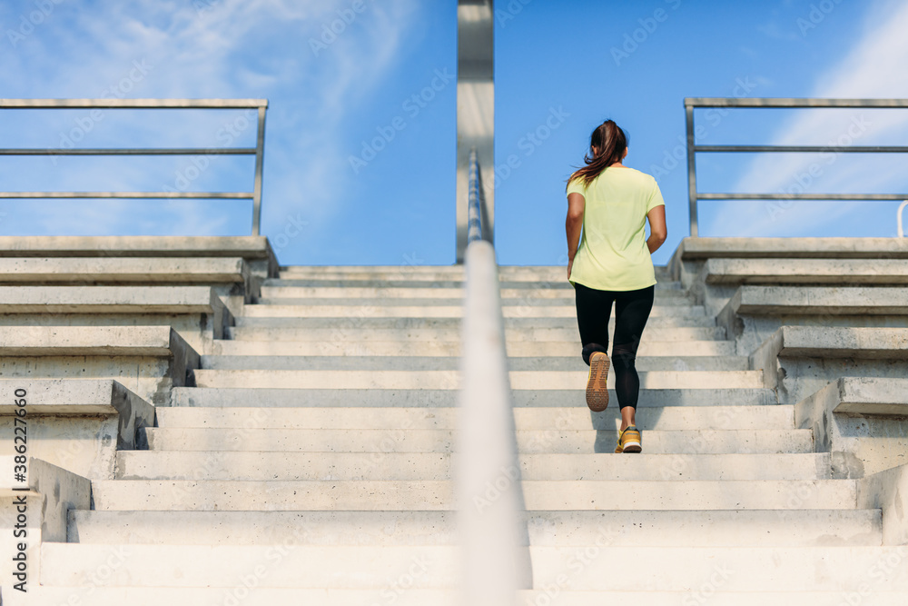 Young female athlete doing run up at local stadium