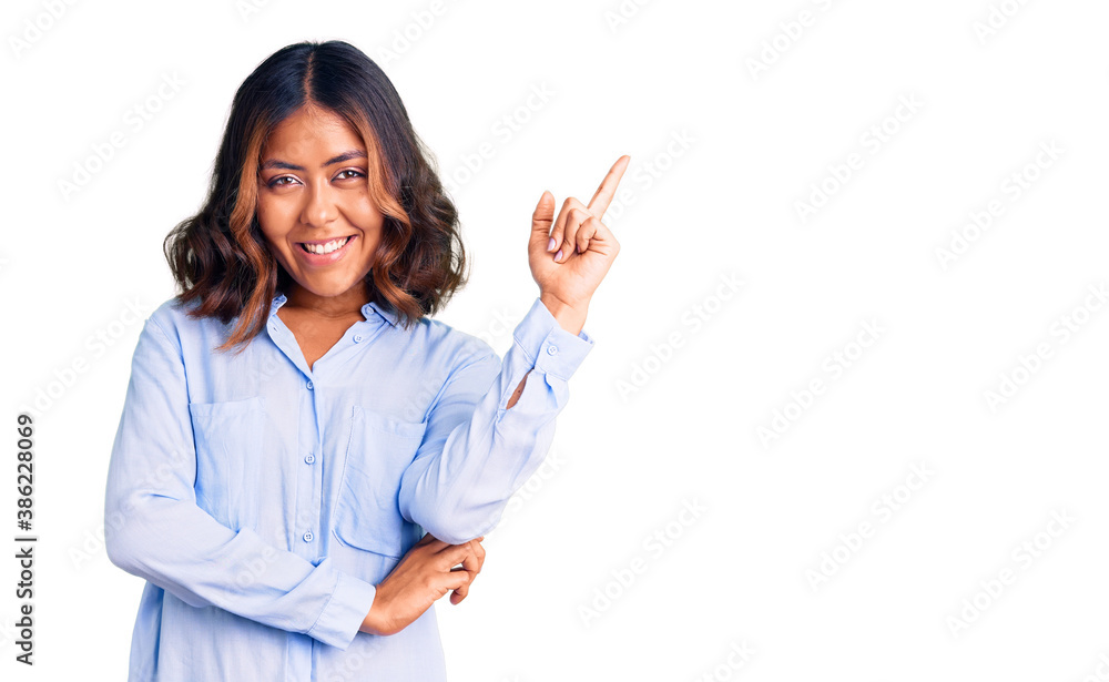 Young beautiful mixed race woman wearing casual business shirt smiling happy pointing with hand and finger to the side Young beautiful mixed race woman wearing casual business shirt smiling happy pointing with hand and finger to the side