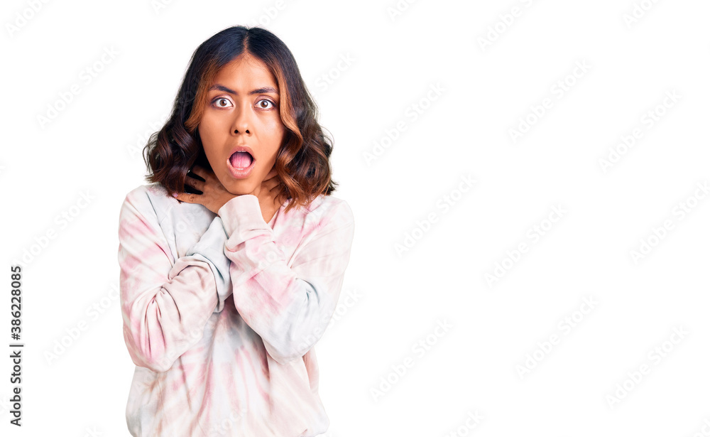 Young beautiful mixed race woman wearing casual tie dye sweatshirt shouting and suffocate because painful strangle. health problem. asphyxiate and suicide concept. Young beautiful mixed race woman wearing casual tie dye sweatshirt shouting and suffocate because painful strangle. health problem. asphyxiate and suicide concept.