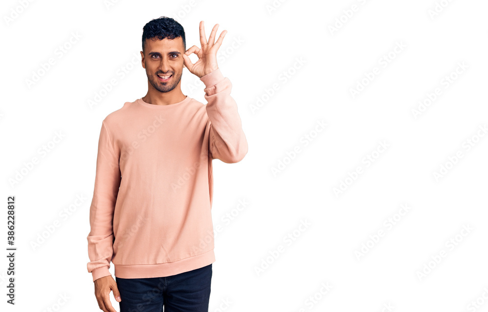 Young hispanic man wearing casual clothes smiling positive doing ok sign with hand and fingers. successful expression. Young hispanic man wearing casual clothes smiling positive doing ok sign with hand and fingers. successful expression.