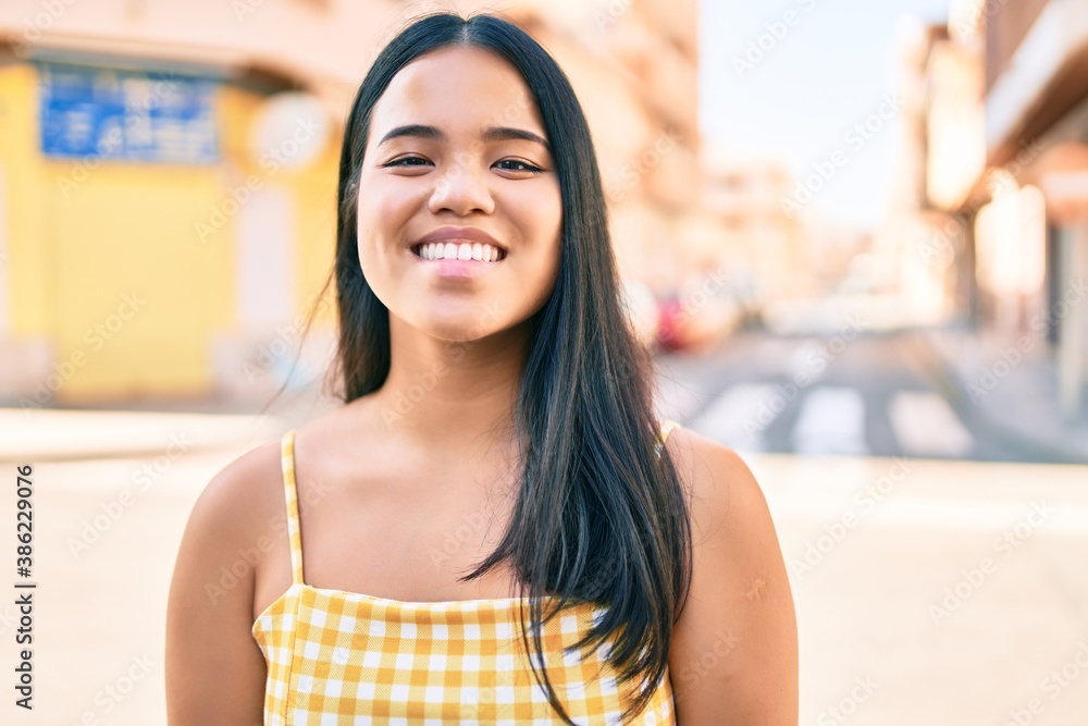 Young asian girl smiling happy at the city