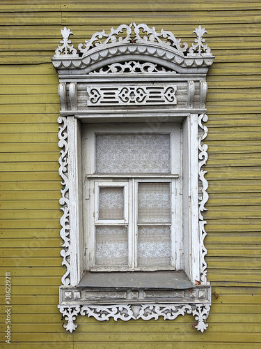Window plenteously decorated by the wooden carving photo