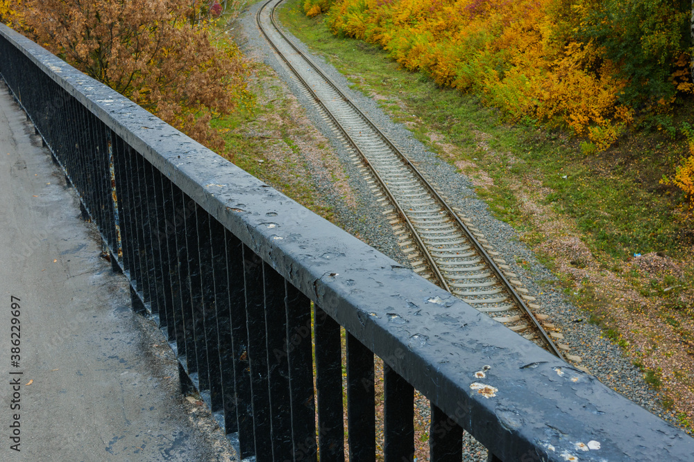 View from the bridge to the railway against the background of autumn trees. High quality photo View from the bridge to the railway against the background of autumn trees. High quality photo