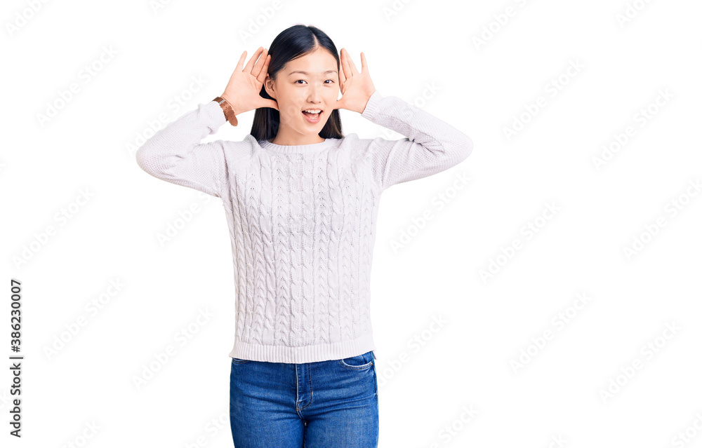Young beautiful chinese woman wearing casual sweater smiling cheerful playing peek a boo with hands showing face. surprised and exited Young beautiful chinese woman wearing casual sweater smiling cheerful playing peek a boo with hands showing face. surprised and exited