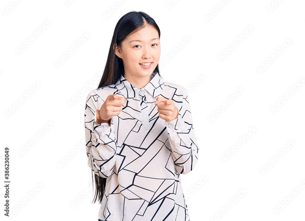 Young beautiful chinese woman wearing casual shirt pointing fingers to camera with happy and funny face. good energy and vibes. Young beautiful chinese woman wearing casual shirt pointing fingers to camera with happy and funny face. good energy and vibes.