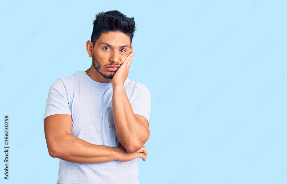 Handsome latin american young man wearing casual clothes thinking looking tired and bored with depression problems with crossed arms. Handsome latin american young man wearing casual clothes thinking looking tired and bored with depression problems with crossed arms.