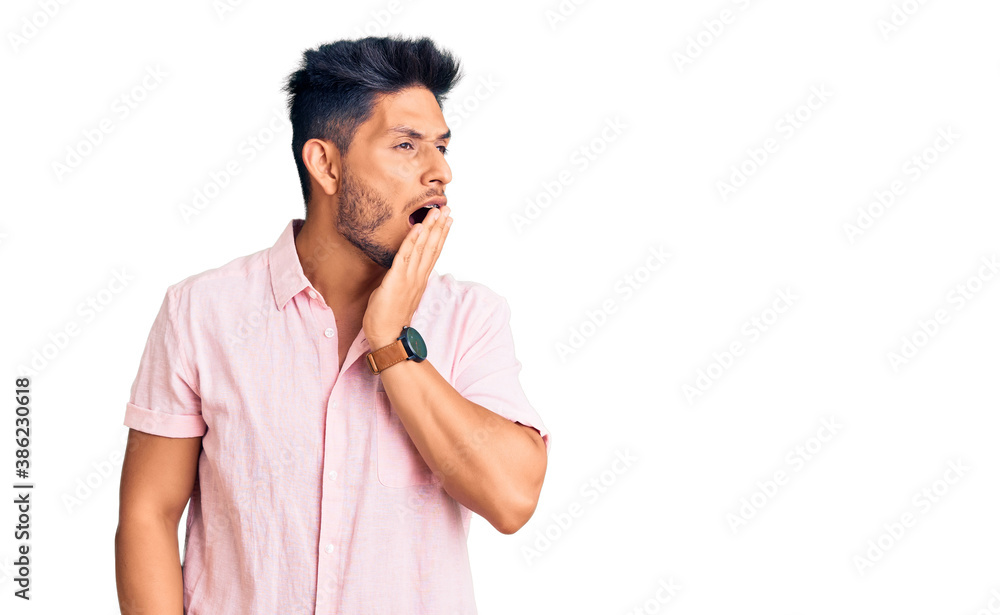 Handsome latin american young man wearing casual summer shirt bored yawning tired covering mouth with hand. restless and sleepiness. Handsome latin american young man wearing casual summer shirt bored yawning tired covering mouth with hand. restless and sleepiness.