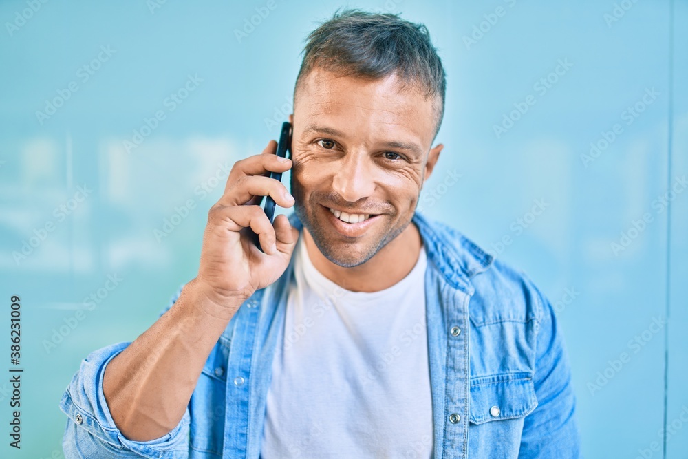 Young caucasian man smiling happy talking on the smartphone at the city. Young caucasian man smiling happy talking on the smartphone at the city.