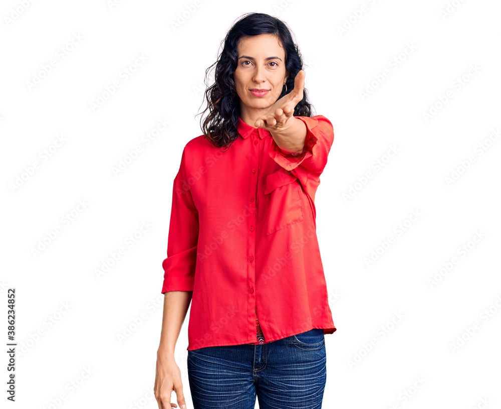 Young beautiful hispanic woman wearing casual clothes smiling friendly offering handshake as greeting and welcoming. successful business. Young beautiful hispanic woman wearing casual clothes smiling friendly offering handshake as greeting and welcoming. successful business.