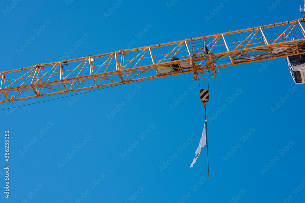 Boom and lifting hook of a yellow construction crane. Boom and lifting hook of a yellow construction crane.