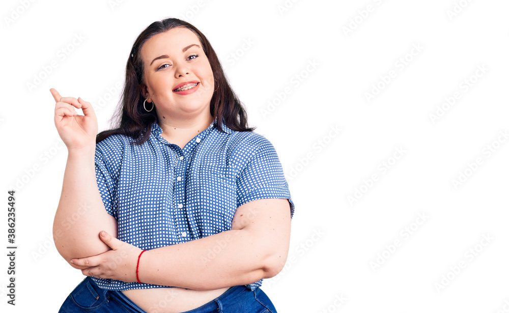 Young plus size woman wearing casual clothes smiling happy pointing with hand and finger to the side Young plus size woman wearing casual clothes smiling happy pointing with hand and finger to the side