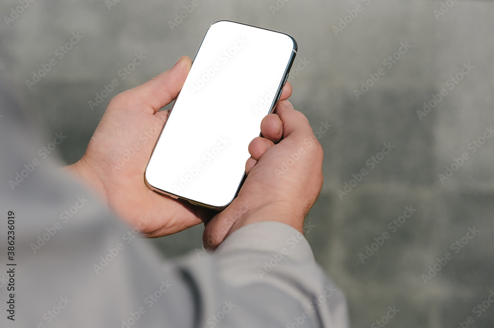 Close up, mock up smartphone, in hands, of a person. against the background of a concrete wall. Close up, mock up smartphone, in hands, of a person. against the background of a concrete wall.