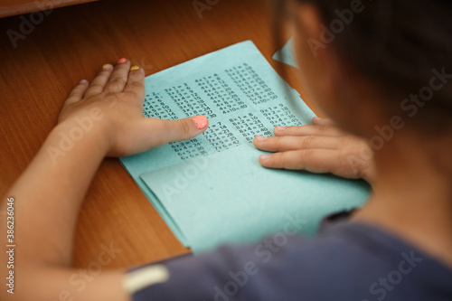 child learns multiplication table at desk homework