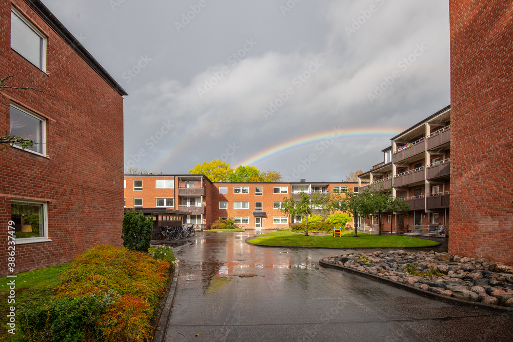 Rainbow over a brick apartment complex.