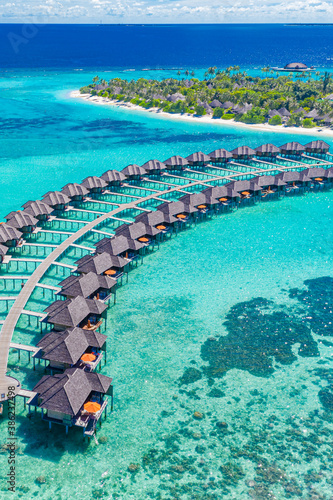 Amazing aerial landscape in Maldives islands. Perfect blue sea and coral reef view from drone or plane. Exotic summer travel and vacation landscape, luxury water villas. Freedom, getaway concept