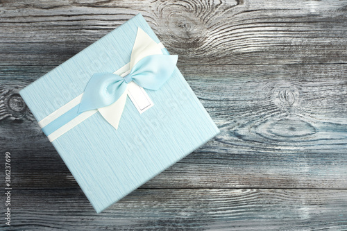 Gift box in blue on a wooden background. The view from the top, festive background.