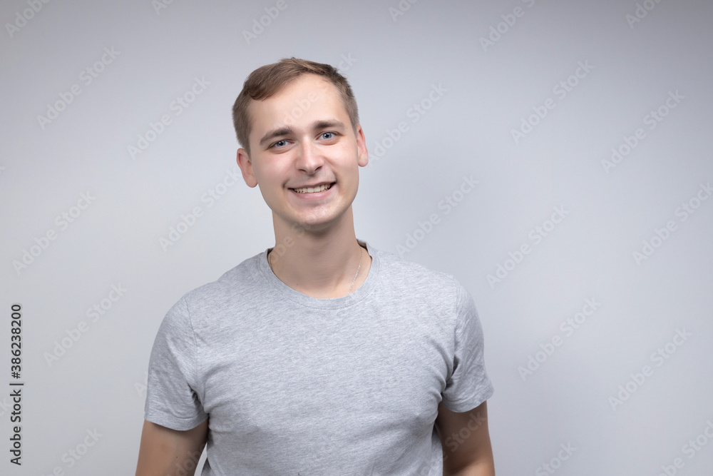 Close-up portrait of a business man looking at the camera and laughing with a sincere smile, isolated on a white-gray background Close-up portrait of a business man looking at the camera and laughing with a sincere smile, isolated on a white-gray background