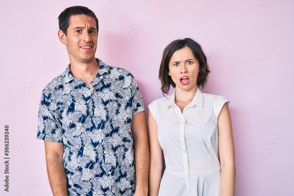 Beautiful couple wearing casual clothes in shock face, looking skeptical and sarcastic, surprised with open mouth Beautiful couple wearing casual clothes in shock face, looking skeptical and sarcastic, surprised with open mouth