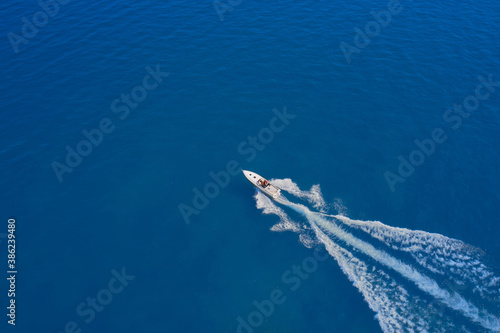 Aerial view luxury motor boat. Drone view of a boat sailing. Travel - image. Motor boat in the sea. Top view of a white boat sailing to the blue sea. Drone view of a boat  the blue clear waters. © Berg