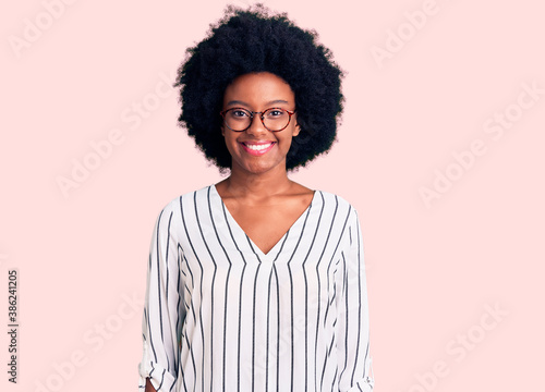 Young african american woman wearing casual clothes and glasses with a happy and cool smile on face. lucky person.