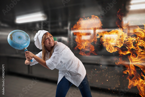 Woman chef is worried becouse the kitchen is on fire photo