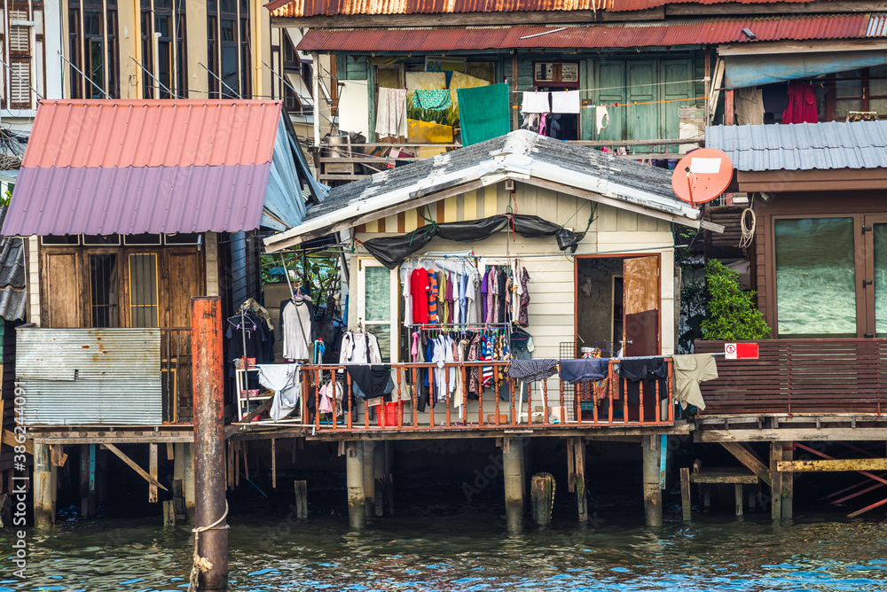 Stilt Houses at a Klong in Bangkok, Thailand. Chao Phraya Riverbank with Lush Vegetation.