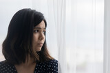 Close up of sad young asian woman look in window distance feeling lonely, lack communication at home. Upset unhappy Vietnamese female loner outcast thinking pondering, suffer from depression.