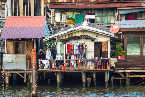Obraz na płótnie Stilt Houses at a Klong in Bangkok, Thailand. Chao Phraya Riverbank with Lush Vegetation. w salonie