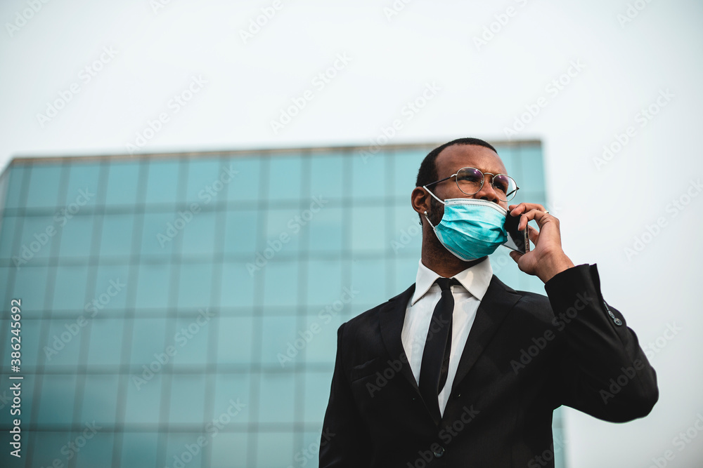 Businessman with a mask and a mobile phone.