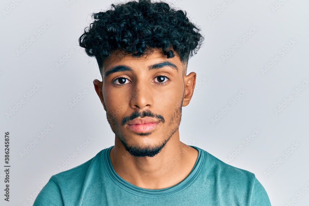 Young arab handsome man wearing casual clothes thinking attitude and sober expression looking self confident Young arab handsome man wearing casual clothes thinking attitude and sober expression looking self confident