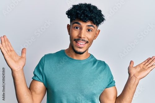 Young arab handsome man wearing casual clothes celebrating victory with happy smile and winner expression with raised hands