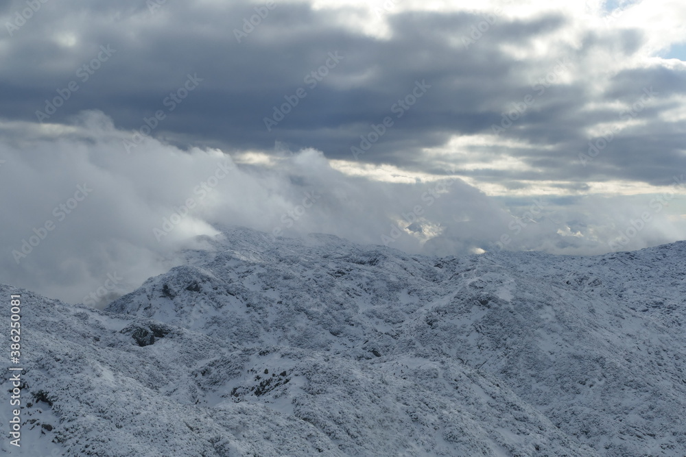 Wolken in verschneiter Berglandschaft