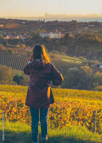 tourist girl looking panorama og costigliole d'asti, piedmont, italy. wine tasting tour tourism photo