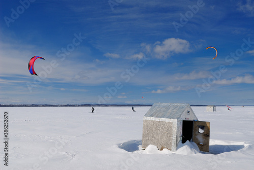 Snowfer and snowkiters with icefishing huts on Lake Simcoe photo